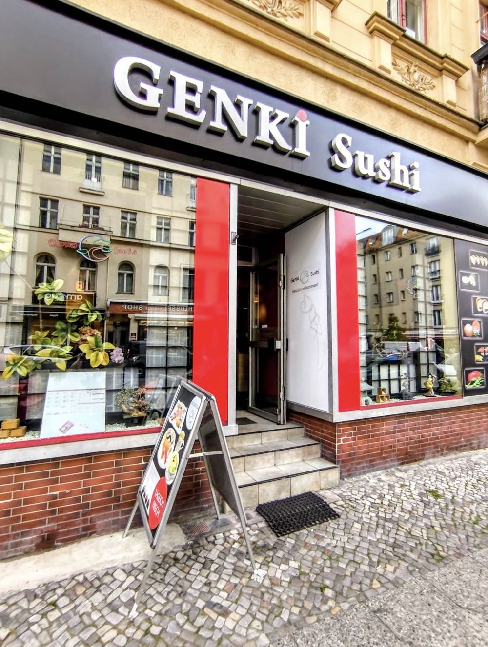 Eingang von Genki Sushi mit rotem Rahmen und Schriftzug