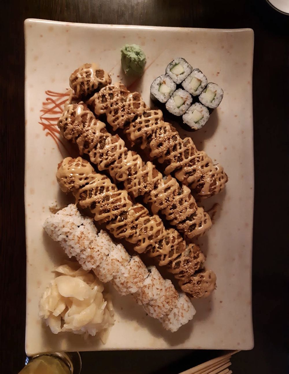 Panierte Rollen mit Sauce und Sesam, dazu Maki